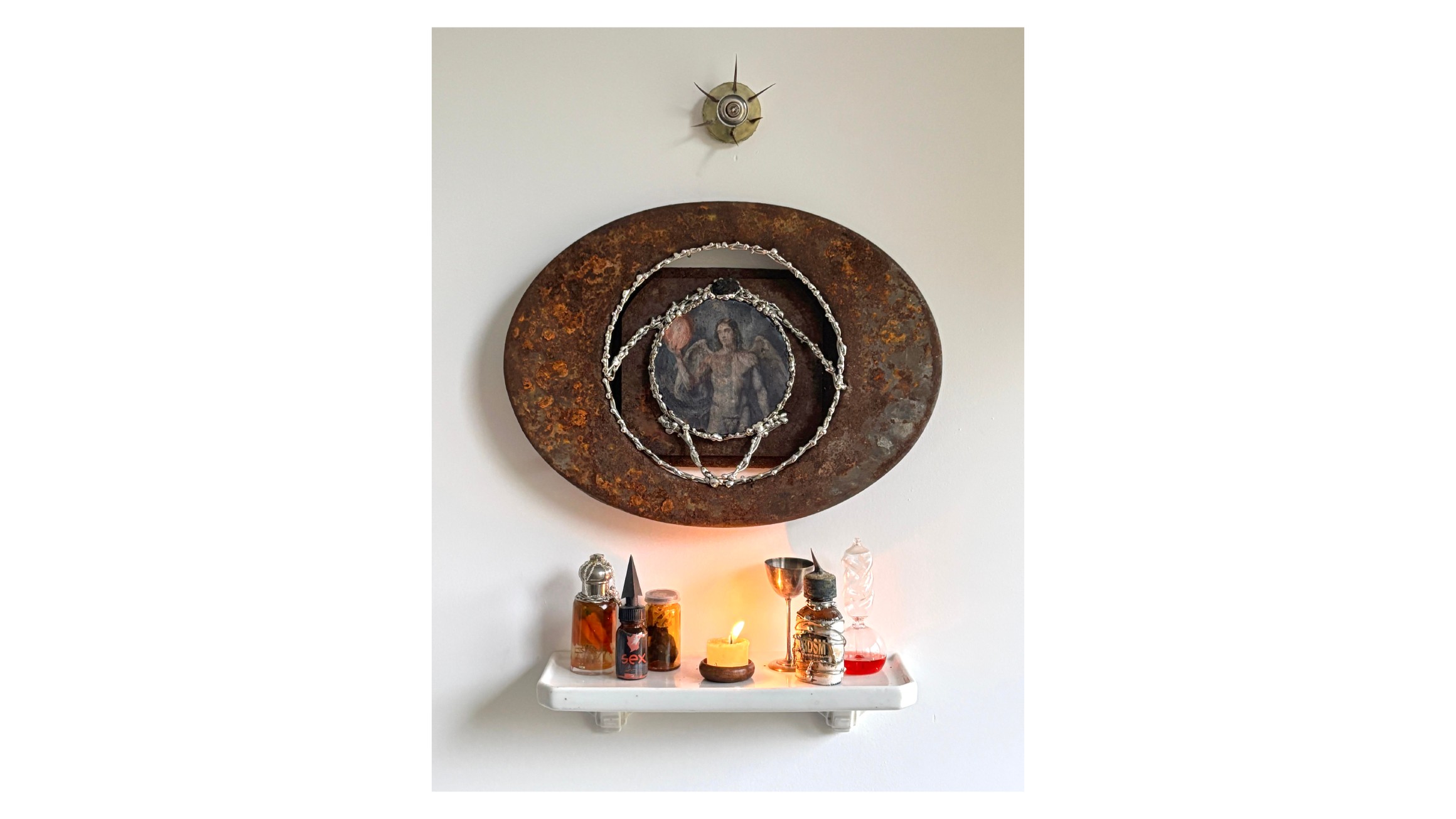 Youri Johnson, *Autel des Sentinelles*, 2024
Elément en métal rouillé, étain, image d’ange, ampoule, épines d’acacia, étagère en céramique, potions diverses. Courtesy the artist & spiaggia libera, Paris.